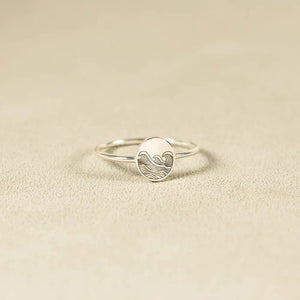Silver ring with engraved wave pattern on oval face