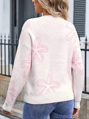 Ivory knit crewneck sweater with pink floral outline pattern and ribbed cuffs and hem.
