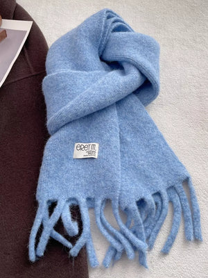 Plush fringe scarf in sky blue with a solid design and cozy texture.