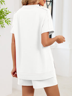 Relaxed white two-piece set with short sleeves, crew neck, and side pockets on shorts.