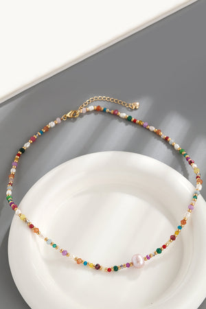 Multicolor beaded gemstone and pearl necklace with gold chain and clasp.