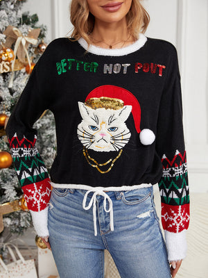 Black knit sweater with festive cat graphic, sequin text, and snowflake sleeves.