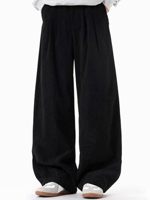 Men's black pleated wide leg trousers with a casual fit.