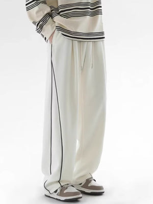 Men's white relaxed fit sweatpants with black side stripes and drawstring waist.