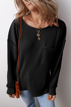 Black ribbed knit long sleeve top with patch pocket and crew neck.