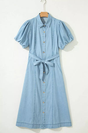 Light blue denim midi dress with collar, puff sleeves, button front, and tie belt.