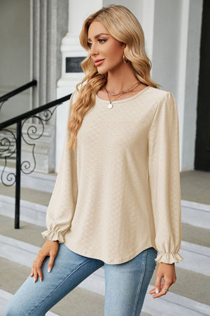 Textured cream puff sleeve blouse with ruffle cuffs and crew neck.