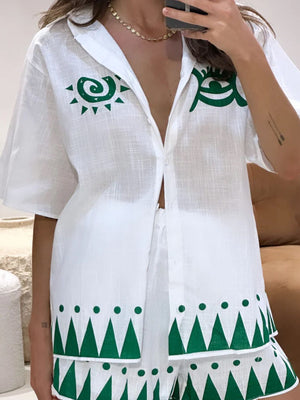White linen co-ord set with green sun and geometric print, button-down shirt and shorts.