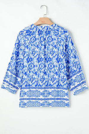 Royal blue ikat print V-neck blouse with border trim and 3/4 sleeves.