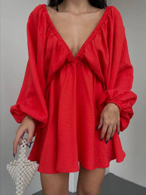 Scarlet ruched V-neck dress with balloon sleeves and textured fabric.