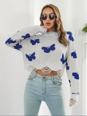 White knit cropped sweater with distressed details and blue butterfly print.
