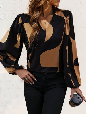 Black and tan geometric print blouse with voluminous sleeves and V-neck.