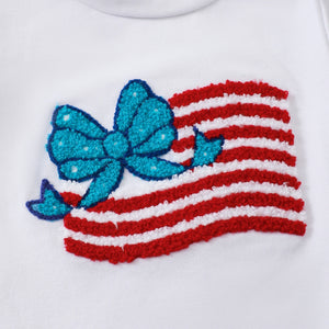 White cotton tee with patriotic applique of red and white striped flag with a blue bow and stars.