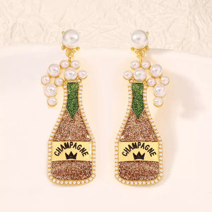 Champagne bottle earrings with pearls and glitter, gold and green accents.