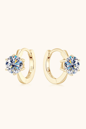Gold moissanite solitaire huggie hoop earrings with clear round-cut stones.