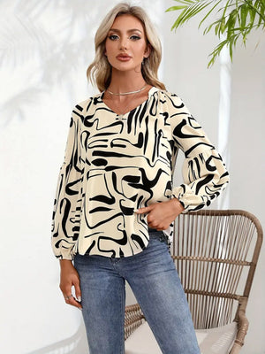 Women's cream top with abstract black scribble print and blouson sleeves.