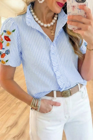 Blue striped cotton shirt with embroidered floral puff sleeves and frill detail.