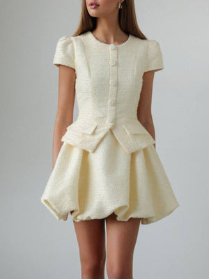 Textured cream button-down dress with short sleeves, peplum waist, and bubble hem skirt.