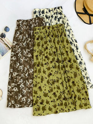 Botanical print midi skirts in black, tan, and olive with crinkled texture.