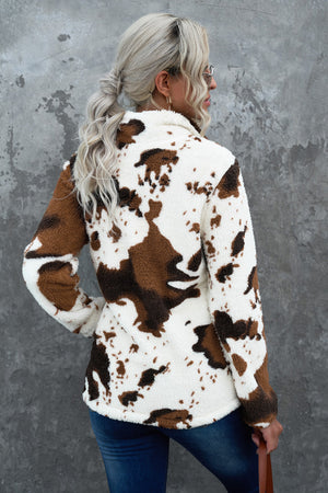 Cowhide sherpa quarter-zip pullover in white with brown pattern, fuzzy texture, and quarter-zip neckline.
