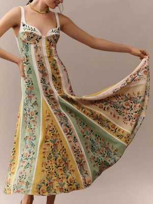 Botanical print sweetheart maxi dress with striped panels and a flowing skirt.
