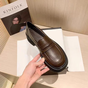 Platform penny loafers in coffee brown leather with a thick sole.