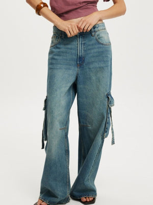 Relaxed fit light blue wash cargo jeans with ankle length and tie details.