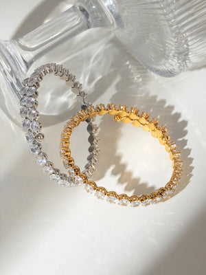 Double row pavé bangle bracelets in silver and gold with clear cubic zirconia stones.