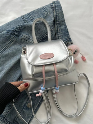 Silver mini leather drawstring backpack with pink beaded accents and fluffy charm.
