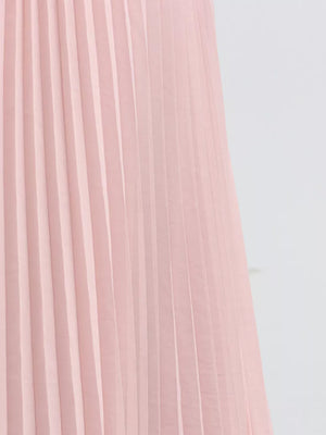 Pink pleated skirt detail of a two-piece ensemble