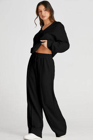 Black relaxed V-neck lounge set with seam detail on wide-leg pants and drawstring waist.