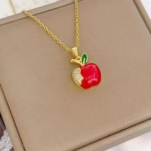 Gold-plated necklace with red apple pendant, green leaf, and crystal accents.