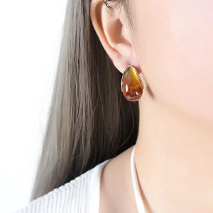 Teardrop resin stud earrings with gold trim, amber and silver tones