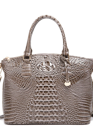 Crocodile embossed satchel bag in taupe with top handle and gold hardware detail.