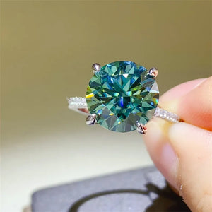 Radiant teal moissanite ring in silver with pavé band.