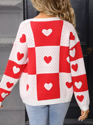 Red and white heart motif knit cardigan with checkered pattern and long sleeves.