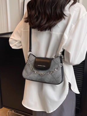 Textured grey shoulder bag with chain strap and black flap detail.