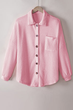 Blush pink waffle knit button-down shirt jacket with a chest pocket and button closure.