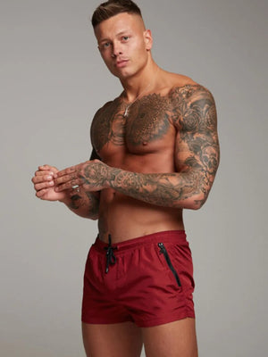 Coastal swim shorts in deep red with zip pockets and drawstring waist