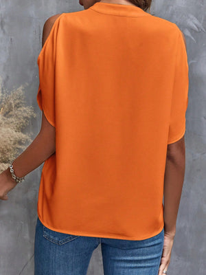 Open-shoulder tangerine blouse with short sleeves and a keyhole neckline detail.