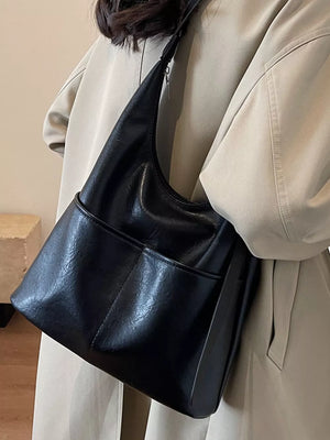 Black leather hobo shoulder bag with adjustable strap and front pockets.