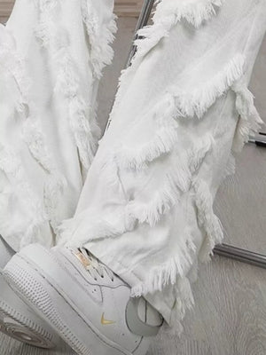 White wide-leg jeans for men with layered fringe detailing.