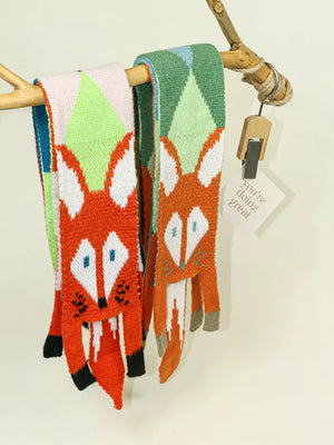 Chunky knit scarves with orange fox design, one Style A with pink and green, one Style B with green and blue.