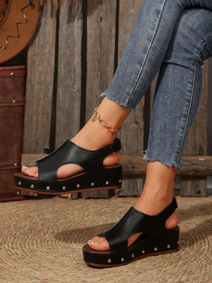Black cutout studded platform sandals with peep toe and ankle strap.