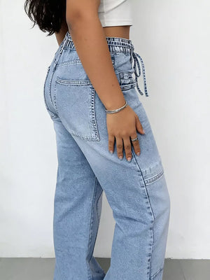 Light wash denim wide-leg cargo jeans with drawstring waist and patch pockets.