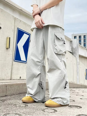 Grey cargo sweatpants with adjustable drawstring details and large cargo pockets.