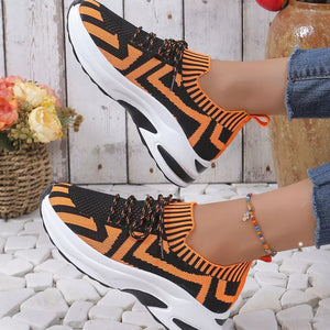 Geometric knit platform sneakers in orange and black with white soles.