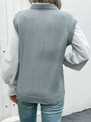 Gray acrylic diamond knit V-neck vest with ribbed trim, layered over a white shirt.