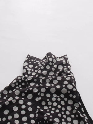 Chic polka dot halter maxi dress with a sheer overlay and ruched detail.