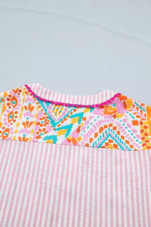Vibrant patchwork ruffle detail blouse with pink stripes and pom trim.